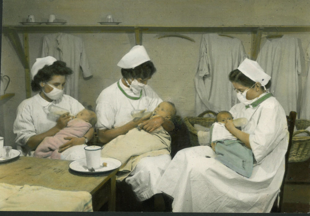 Nurses bottle-feeding infants, 1940s