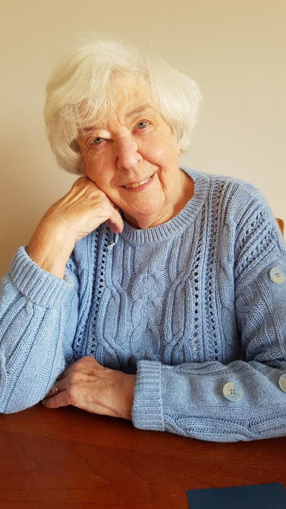 Photo of Betty Field wearing a blue knit cardigan, head resting lightly on hand.