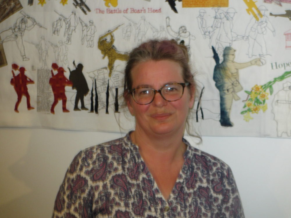 Photo of Andrea Finch in a grey, white and pink patterned dress.